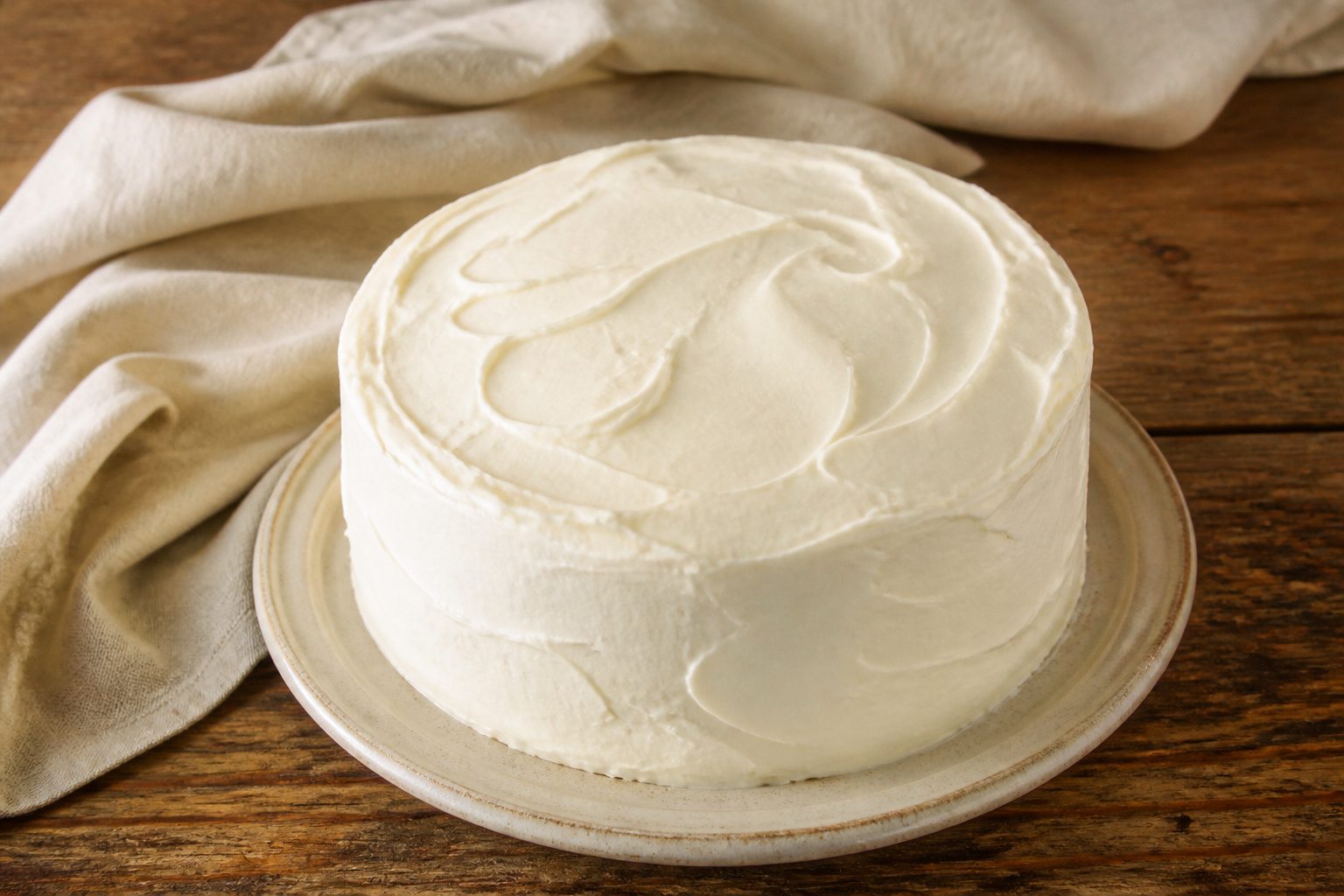 A simple white cake on a plate, highlighting its pale color and soft appearance.